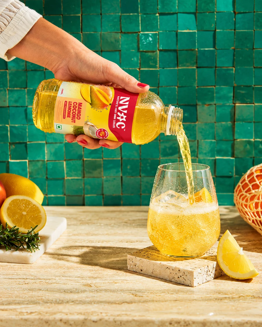 NVOC Mango Coconut Lemon poured over ice against green tiles